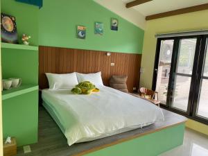 a bedroom with a bed with a stuffed frog on it at Blue Sea and Sunny B&B in Toucheng +47 photos