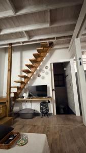 a living room with a staircase and a television at Moorea Fare Korail in Temae