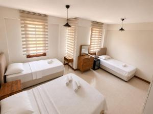 a room with two beds and a table and two tables at White City Pension in Antalya
