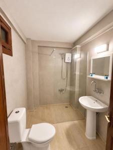a bathroom with a toilet and a shower and a sink at White City Pension in Antalya +34 photos