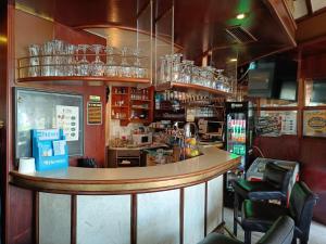 a bar in a restaurant with a counter and chairs at Double Room Stegersbach in Stegersbach