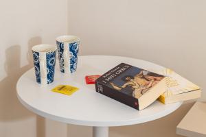 a white table with a book and two vases on it at Ánemos b&b in Termoli