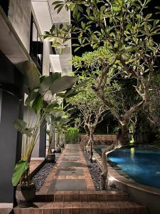 a courtyard with trees and a swimming pool at White Rock Lodge in Nusa Dua