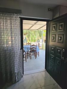 an open door to a patio with a table and chairs at Garyfallia's House in Korifásion