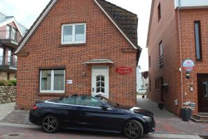 a black car parked in front of a brick building at Appartment Vermietung Lütje in Büsum