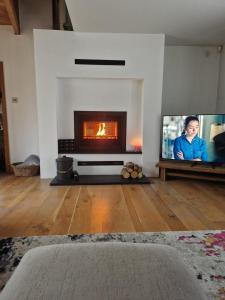 a living room with a fireplace and a tv at The Barn in Crumlin