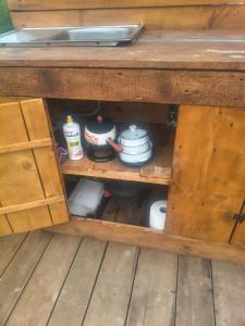 a wooden cabinet filled with pots and pans at namiot przy podeście in Leszczawka
