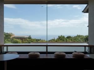 a room with a large window and two tables and chairs at Soratoniwa Atami Izusan in Atami +42 photos