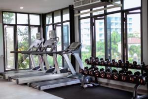a gym with several tread machines and windows at UR The Private Huahin in Hua Hin