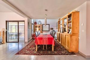 a dining room with a red table and chairs at villa d'engance et ses dépendances in Nîmes