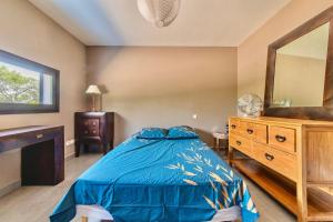 a bedroom with a bed and a dresser and a mirror at villa d'engance et ses dépendances in Nîmes