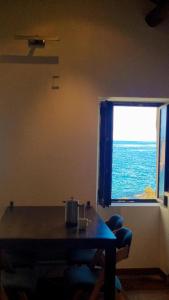 a table and a window with a view of the ocean at Maison de pêcheur les pieds dans l'eau in Ersa +4 photos