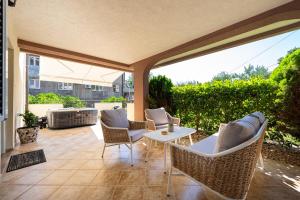 a patio with wicker chairs and a table at Villa Dorotea in Tivat