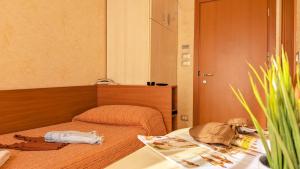 a small bedroom with a bed and a table at Hotel Condor in Milano Marittima