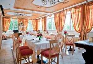 a dining room with tables and chairs and windows at Wellness e Resort Stella Delle Alpi in Ronzone