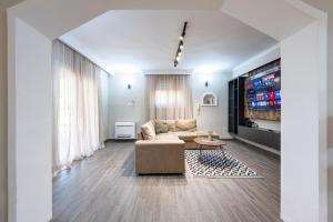 a living room with a couch and a tv at Villa Dorotea in Tivat