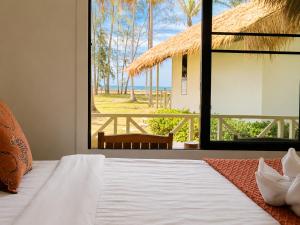 a bedroom with a bed and a view of the ocean at Phangan Chalet Bungalows in Chaloklum