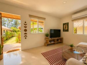 a living room with a couch and a tv at Phangan Chalet Bungalows in Chaloklum