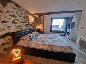 a bedroom with a bed with a stone wall at Maison de pêcheur les pieds dans l'eau in Ersa