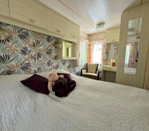 a teddy bear sitting on a bed in a hotel room at OW Mikomania in Charzykowy