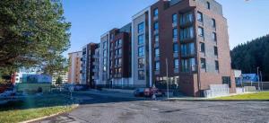 a large brick building with a parking lot in front of it at Apartmán 504 Svit in Jezersko