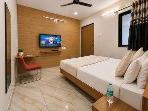 a bedroom with a bed and a television in it at Hotel RR Palace in Rajkot