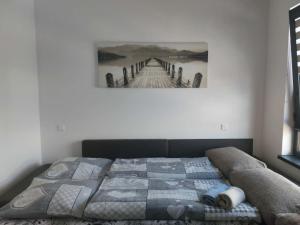 a bed in a bedroom with a picture of a pier at Apartmán 504 Svit in Jezersko