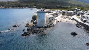 an aerial view of a lighthouse in the water at Maison de pêcheur les pieds dans l'eau in Ersa