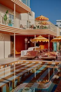 a pool at a hotel with chairs and umbrellas at Riviera Hotel Menorca in Ciutadella