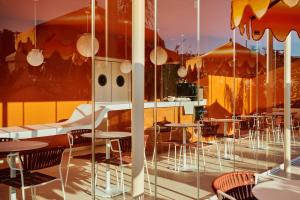 a restaurant with tables and chairs in a room at Riviera Hotel Menorca in Ciutadella