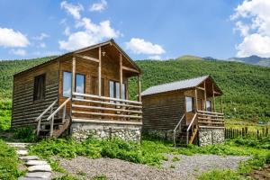 a small wooden house in the middle of a mountain at Ushguli Cabins l Cafe in Ushguli