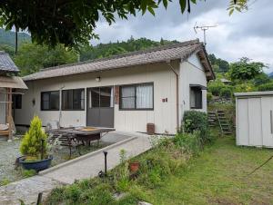 a white house with a table in front of it at 平屋宿まえの in Motoyama