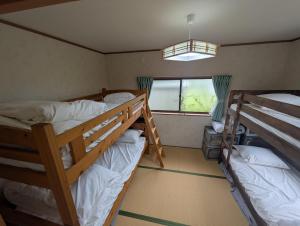 two bunk beds in a room with a window at 平屋宿まえの in Motoyama