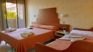 a bedroom with two beds and a stair case at Hotel Condor in Milano Marittima