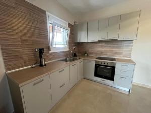 a kitchen with white cabinets and a sink at Sky Apartment in Ofrínion