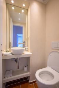 a bathroom with a sink and a toilet and a mirror at Horizon House - Beachfront Escape in Nerántza +8 photos