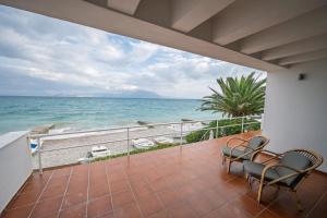 a balcony with chairs and a view of the ocean at Horizon House - Beachfront Escape in Nerántza