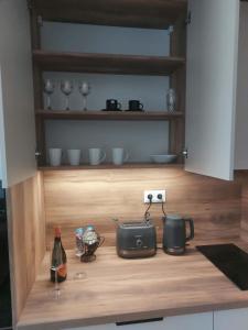 a kitchen counter with a table with a toaster and a bottle of wine at Apartmán 504 Svit in Jezersko