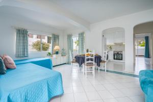 a bedroom with a blue bed and a living room at Prainha Lounge in Alvor