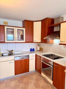 a kitchen with wooden cabinets and a stove top oven at Villa Ocean Breeze First Row in Brist