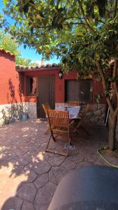 a wooden table and a bench under a tree at Jinoba25 in Castillo de Bayuela
