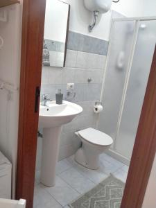 a bathroom with a sink and a toilet and a shower at Le Camelie camera in Bosa +17 photos
