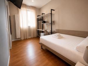 a bedroom with a white bed and a wooden floor at Foresteria Via Italia - Rooms & Suite in Rho