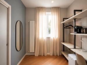 a living room with a mirror and a window at Foresteria Via Italia - Rooms & Suite in Rho +42 photos