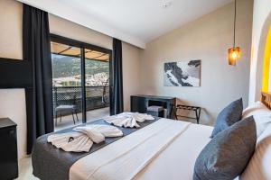 a bedroom with a bed and a large window at Çınar Butik Hotel in Kaş