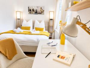 a hotel room with a bed and a desk with a lamp at 'GoldPath' OldTown - Apartments Passau in Passau