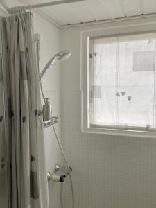 a shower in a bathroom with a window at Herning syd - Lind in Herning