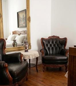 a bedroom with a mirror and two chairs and a table at Pałac Przybyszewo in Przybyszewo