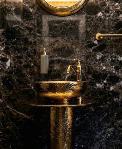 a bathroom with a gold sink and a mirror at Pałac Przybyszewo in Przybyszewo