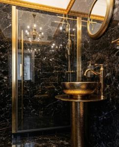a bathroom with a gold sink and a mirror at Pałac Przybyszewo in Przybyszewo